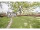Large backyard with a shed, green grass, and mature trees, offering plenty of space for outdoor activities and relaxation at 2319 E 40Th St, Anderson, IN 46013