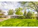 Charming single-story home with a lush green lawn and mature trees creating a picturesque setting at 2319 E 40Th St, Anderson, IN 46013