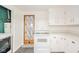 Bright kitchen featuring white appliances, cabinets, and a door with unique patterned curtain at 2319 E 40Th St, Anderson, IN 46013