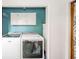 Laundry area features washer and dryer, cabinet storage, and water heater at 2319 E 40Th St, Anderson, IN 46013