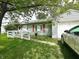 View of front of home with a white picket fence, ramp, muted red shutters and an attached garage at 2337 N Webster N Ave, Indianapolis, IN 46219