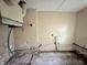 Utility room awaiting renovation, with exposed pipes and wall damage, a blank canvas for upgrades and customization at 2337 N Webster N Ave, Indianapolis, IN 46219