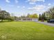 Home's exterior featuring a sprawling yard, driveway, and an attached garage at 2399 E Mckay Rd, Shelbyville, IN 46176