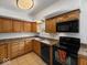 Functional kitchen featuring oak cabinets, dark appliances, and durable countertops at 2399 E Mckay Rd, Shelbyville, IN 46176