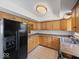 Functional kitchen featuring oak cabinets, dark appliances, and durable countertops at 2399 E Mckay Rd, Shelbyville, IN 46176