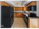 Well-lit kitchen with oak cabinets, black appliances, and ceramic tile floors at 2399 E Mckay Rd, Shelbyville, IN 46176