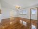 Bright living room with polished hardwood floors, ceiling fan, and large window at 2399 E Mckay Rd, Shelbyville, IN 46176