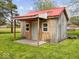 Rustic outbuilding with a red roof, white door and small covered porch at 2399 E Mckay Rd, Shelbyville, IN 46176