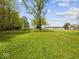Expansive green yard with the main home and various outbuildings in view at 2399 E Mckay Rd, Shelbyville, IN 46176