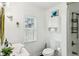Bright bathroom featuring a white sink, toilet, cabinet, and a window bringing in natural light at 253 E Minnesota St, Indianapolis, IN 46225