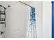 Bathroom with a clean white bathtub and shower featuring a stylish blue and white shower curtain at 253 E Minnesota St, Indianapolis, IN 46225
