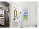 Bright bathroom featuring a decorative mirror, white sink, and stainless steel refrigerator in the doorway at 253 E Minnesota St, Indianapolis, IN 46225