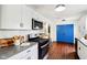 Modern kitchen with stainless steel appliances, white cabinetry, and a breakfast bar for casual dining at 253 E Minnesota St, Indianapolis, IN 46225