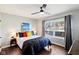 Comfortable main bedroom featuring hardwood floors, a ceiling fan, and a large window with natural light at 253 E Minnesota St, Indianapolis, IN 46225