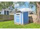 Sturdy blue storage shed with a white door, nestled in a green backyard setting at 253 E Minnesota St, Indianapolis, IN 46225