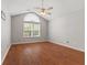Large bedroom with vaulted ceiling, ceiling fan, and large arched window overlooking mature trees at 2726 Reflection Way, Greenwood, IN 46143