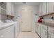 Updated laundry room with tile floor, white cabinets, and granite countertops at 2726 Reflection Way, Greenwood, IN 46143