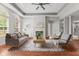 Bright living room featuring tray ceiling, modern fireplace, neutral color palette, and rich hardwood floors at 2726 Reflection Way, Greenwood, IN 46143