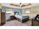 Cozy bedroom featuring a tray ceiling with a ceiling fan, and two windows for natural light at 2769 S 800 W, Indianapolis, IN 46239