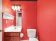 Red half-bathroom featuring a small sink and toilet at 3162 Hazel Foster Dr, Carmel, IN 46033