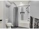 Updated bathroom boasts gray tile floors and tiled tub surround at 3162 Hazel Foster Dr, Carmel, IN 46033