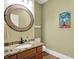 Charming powder room featuring a wood vanity, granite counters, and decorative mirror at 3162 Hazel Foster Dr, Carmel, IN 46033