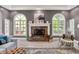 Charming living room with a brick fireplace, large windows, and stylish seating, exuding warmth and comfort at 3162 Hazel Foster Dr, Carmel, IN 46033