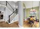 Elegant staircase with hardwood floors, black handrails and a view to an adjacent dining room at 3162 Hazel Foster Dr, Carmel, IN 46033