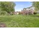 Two-story house featuring a large wooden deck, swing set and lush green lawn at 320 Thornberry Dr, Carmel, IN 46032