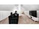 Spacious attic featuring a black couch, work area, television and neutral-colored carpet at 329 W Hampton Dr, Indianapolis, IN 46208