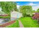 Garage and backyard featuring mature trees and landscaping and brick-paver walkway at 329 W Hampton Dr, Indianapolis, IN 46208