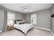 Comfortable bedroom with light green walls, two windows, a ceiling fan, and a bed with neutral bedding at 329 W Hampton Dr, Indianapolis, IN 46208