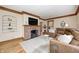 Comfortable living room with a brick fireplace, hardwood floors, and a plush brown sectional at 329 W Hampton Dr, Indianapolis, IN 46208