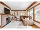 Bright living room featuring a brick fireplace, hardwood floors, and a cozy brown sectional couch at 329 W Hampton Dr, Indianapolis, IN 46208