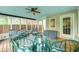 The sunroom features a ceiling fan, lots of windows, and stylish striped furniture at 329 W Hampton Dr, Indianapolis, IN 46208
