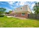 A two-story home's brick exterior and well-maintained lawn, complete with a backyard patio and wooden fence at 3505 Autumn Ct, Columbus, IN 47203