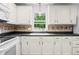 Kitchen area showcasing white cabinets, black hardware, and a window view at 3505 Autumn Ct, Columbus, IN 47203