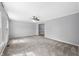 Spacious living room featuring plush carpeting, fresh gray paint, and a ceiling fan for added comfort at 3505 Autumn Ct, Columbus, IN 47203