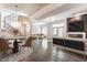 Open-concept living room with hardwood floors, modern furniture, and a dining area with decorative lighting and black-iron staircase at 355 E Ohio St # 314, Indianapolis, IN 46204
