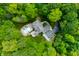Stunning aerial view of a home surrounded by lush greenery and featuring a private backyard pool and deck at 4128 Whitetail Woods Dr, Bargersville, IN 46106