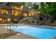 Pool view from backyard at twilight with house, lighting, and water features at 4128 Whitetail Woods Dr, Bargersville, IN 46106