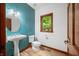 Charming powder room with vibrant blue backsplash, pedestal sink, and natural light at 4128 Whitetail Woods Dr, Bargersville, IN 46106