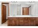 Bright main bathroom featuring double sinks, wooden cabinets, a large mirror, and tile floor at 4128 Whitetail Woods Dr, Bargersville, IN 46106