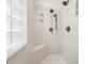 Bright walk-in shower with multiple shower heads, seating, and a glass block window at 4128 Whitetail Woods Dr, Bargersville, IN 46106