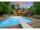 Backyard swimming pool with diving board and an expansive patio, perfect for outdoor entertaining at 4128 Whitetail Woods Dr, Bargersville, IN 46106
