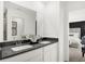 Bathroom featuring dual sinks, sleek countertops, and a view into an adjacent bedroom space at 4405 Mendocino Blvd, Indianapolis, IN 46239