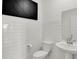 Stylish powder room featuring subway tile walls, a modern vanity, and a sleek black accent wall at 4411 Mendocino Blvd, Indianapolis, IN 46239