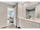 Well-lit bathroom featuring a double vanity, tile flooring, and a view to the primary bedroom, enhancing the sense of space at 4518 Laughter Ln, Indianapolis, IN 46235