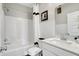 Bright bathroom featuring white subway tile, white shower tub, and white sink vanity with stainless steel faucet at 4518 Laughter Ln, Indianapolis, IN 46235