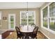 A dining area is filled with natural light, has access to the backyard and features a simple yet elegant wooden table at 4602 Amesbury Pl, Westfield, IN 46062